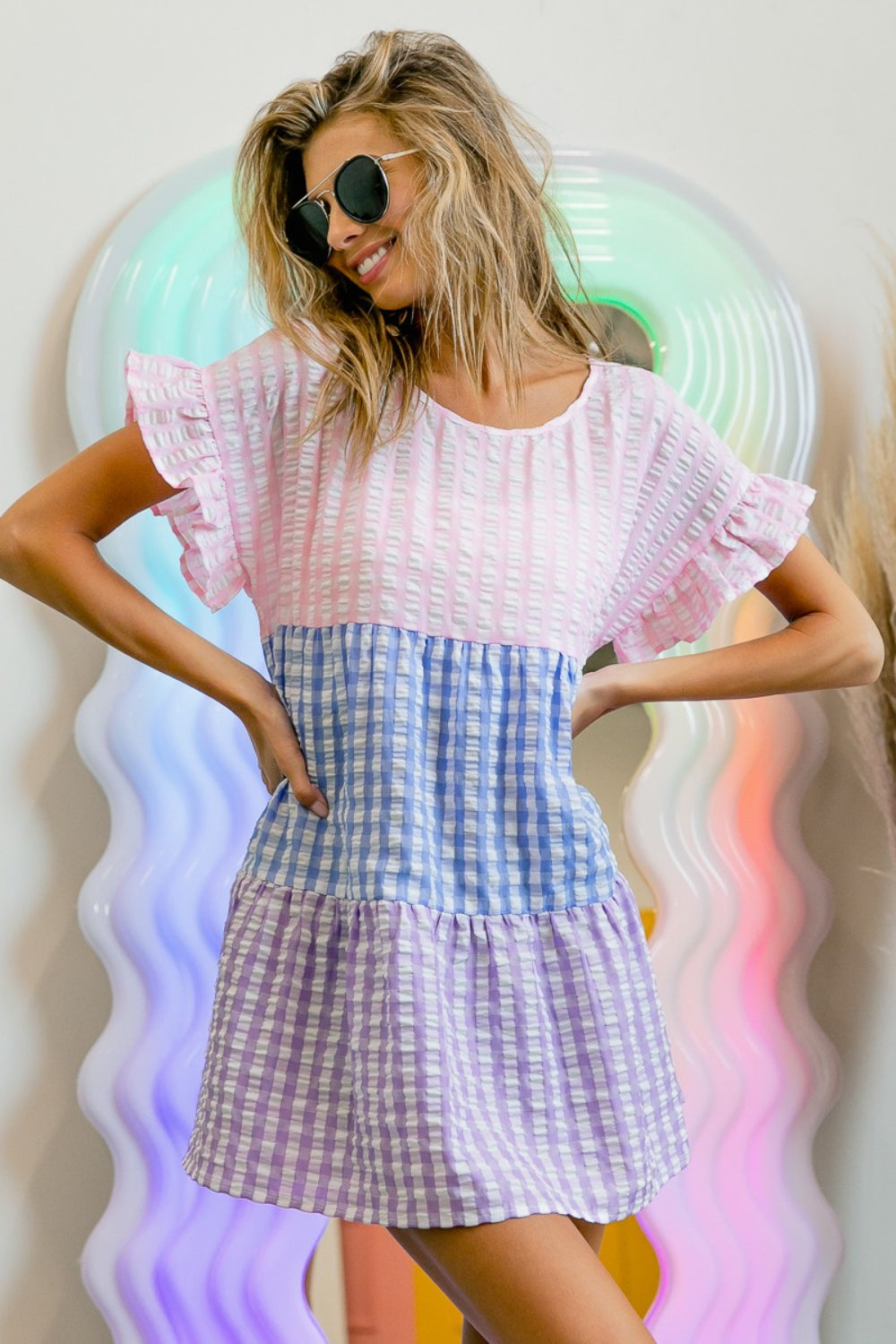 BiBi Plaid Color Block Tiered Top in pink, blue, and purple plaid design, highlighted by ruffled sleeves and a flowy silhouette for casual wear.