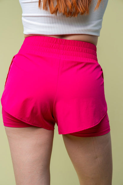 Back view of White Birch pink high-waisted knit shorts, showcasing the layered design and smooth fit with built-in cycling shorts.