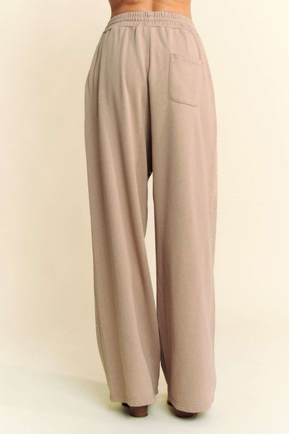 Back view of Davi & Dani rhinestone drawstring wide-leg pants in beige, showcasing a single back pocket and relaxed fit.