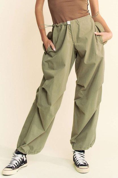 Davi & Dani drawstring baggy pants with pockets in olive green, featuring a relaxed fit and elastic cuffs, styled with sneakers.