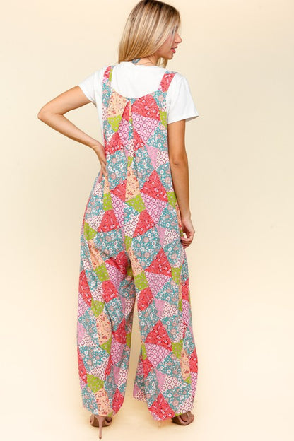 Back view of Haptics full-size printed wide-leg overalls featuring vibrant patchwork print and relaxed fit with side pockets.