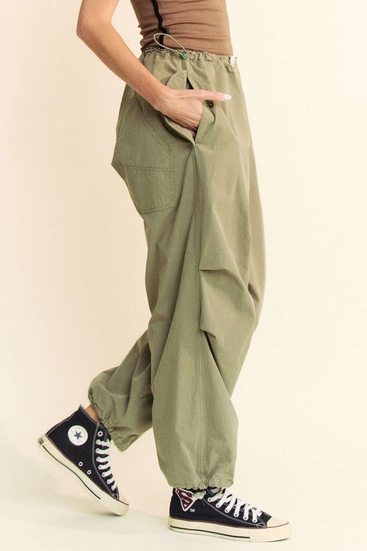 Side view of Davi & Dani drawstring baggy pants with pockets in olive green, highlighting the loose fit and functional side pockets.