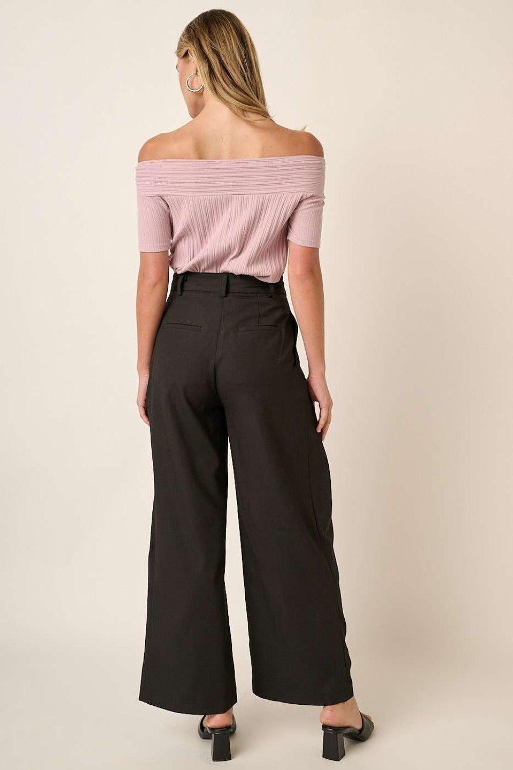 Back view of Mittoshop deep pleated high waisted wide leg pants paired with a pink off-shoulder top, highlighting tailored details.