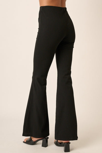 Back view of Mittoshop Crepe Knit Elastic Waist Flare Leg Pants in black, showcasing the smooth fit and flared leg style.